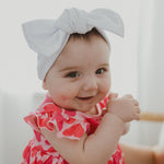 baby wearing white ribbed headband with bow 